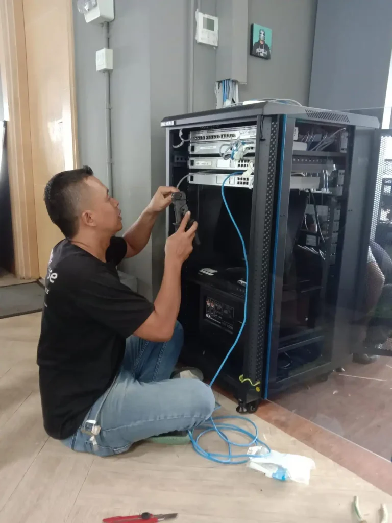 teknisi instalasi ip pbx sedang koneksi kabel utp