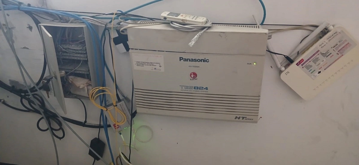 Teknisi sedang memperbaiki PABX Panasonic di workshop